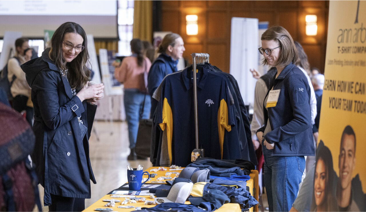 Conference attendees stop by the ann arbor t-shirt company table